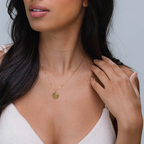 Female wearing the gold spiderweb pendant with paperclip chain 