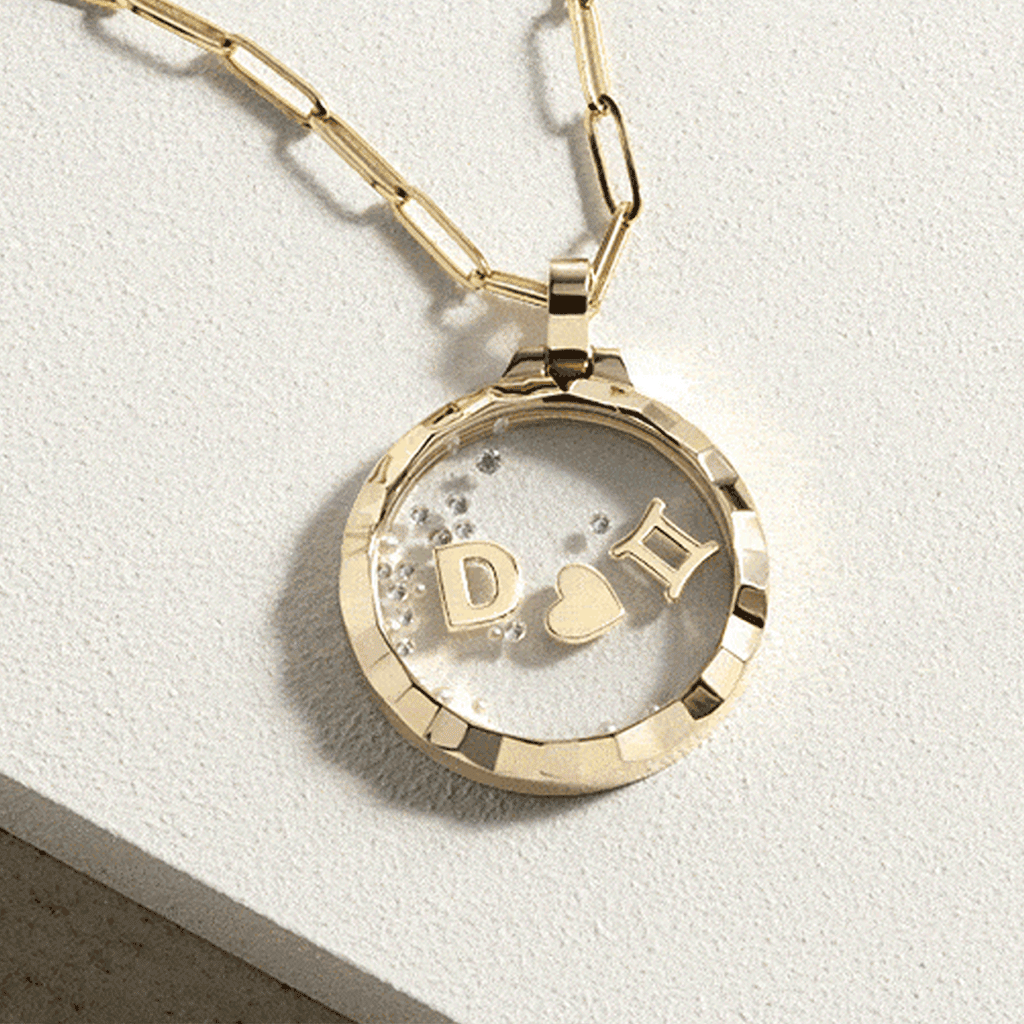 gold locket pendant with mini charms and loose diamonds inside